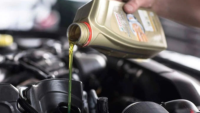 castrol oil is poured into container in a land rover vehicle