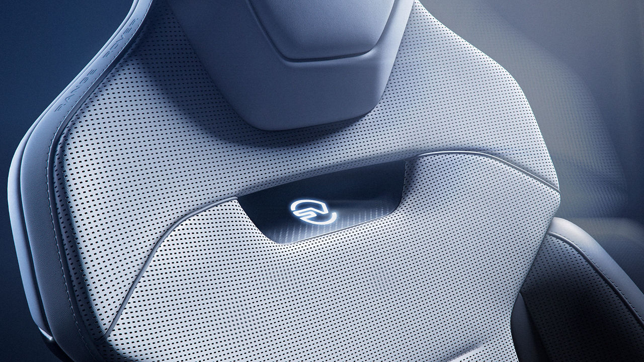 Close up of Range Rover Sport SV Carbon seat detailing in colours light grey and dark grey. SV badge is shown in white lighting