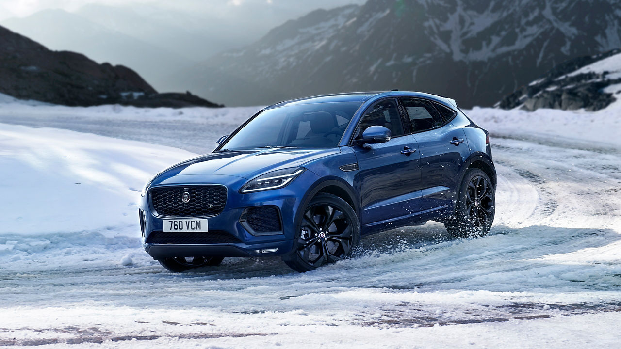 Jaguar E-Pace running on ice road with  Snow Hill background
