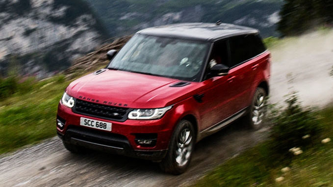 Red Range Rover driving in mountain range