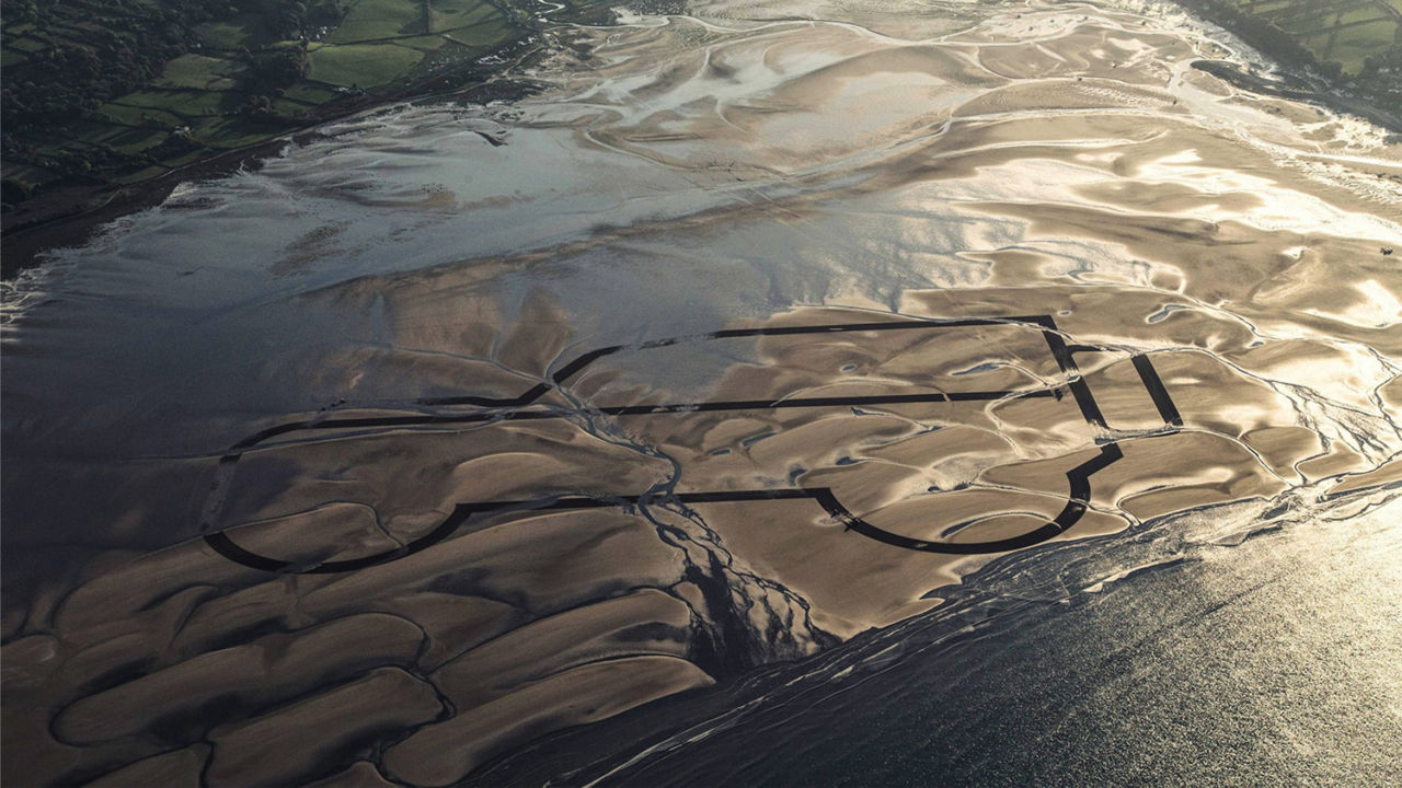 Sand drawing of the original Land Rover shape on the beach at Red Wharf Bay in Anglesey