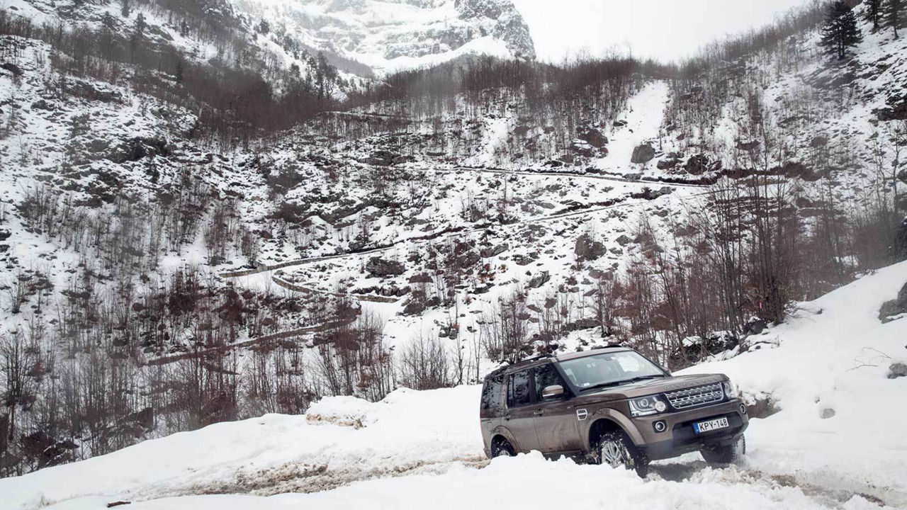 Land Rover Vehicle Driving Through Snow