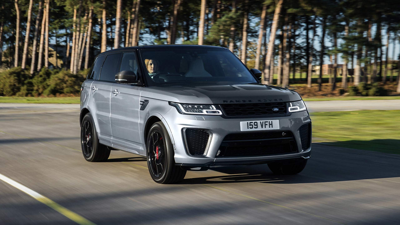 Woman driving Range Rover Sport onto the city road