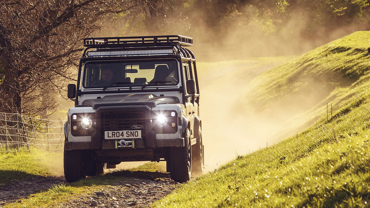 Defender driving in forest off Road