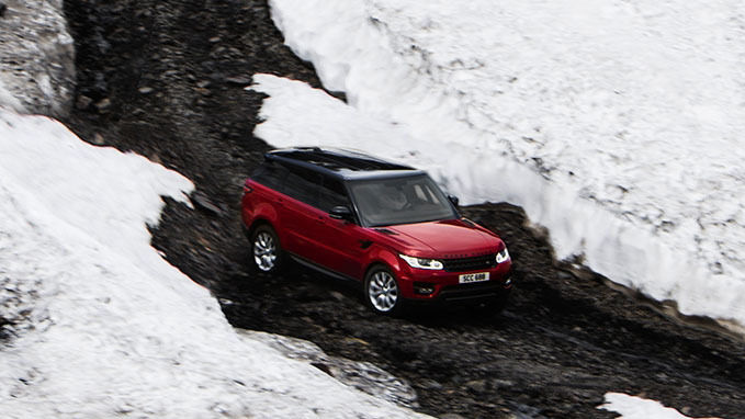 Red Range Rover driving through snow