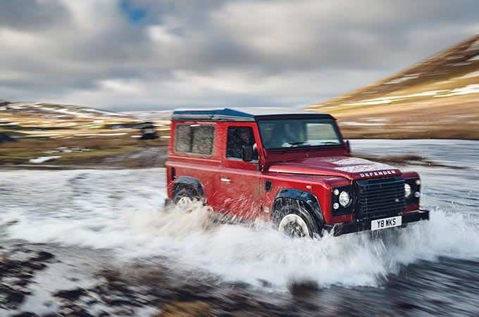 Red Range Rover going through water