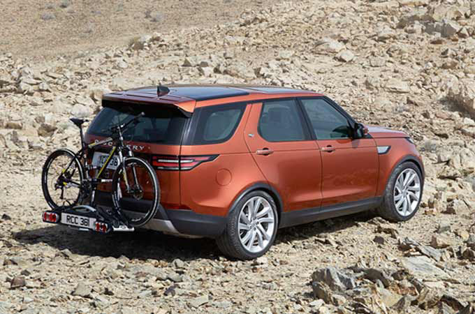 Orange Range Rover with bike behind