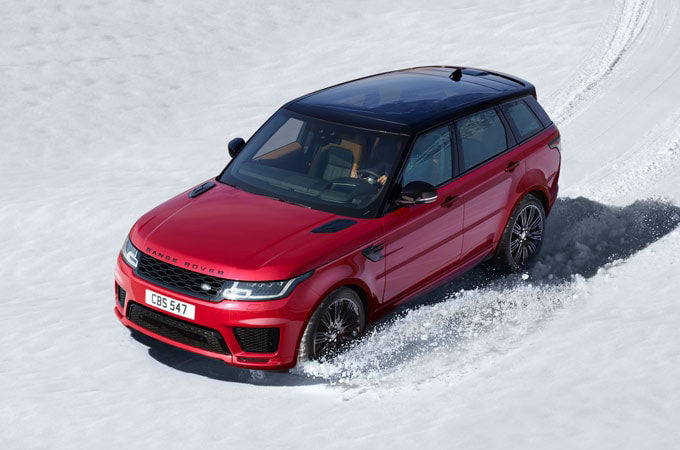 Range Rover Sport in red driving in snow