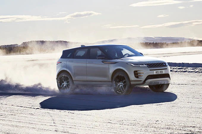 White Range Rover drive through snow