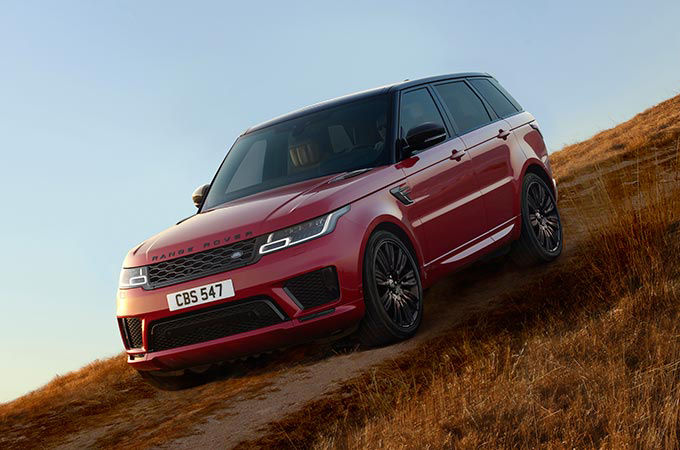 Range Rover Sport in red parked in fields