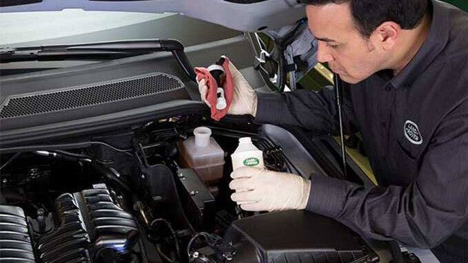 Mechanic servicing an engine of a car