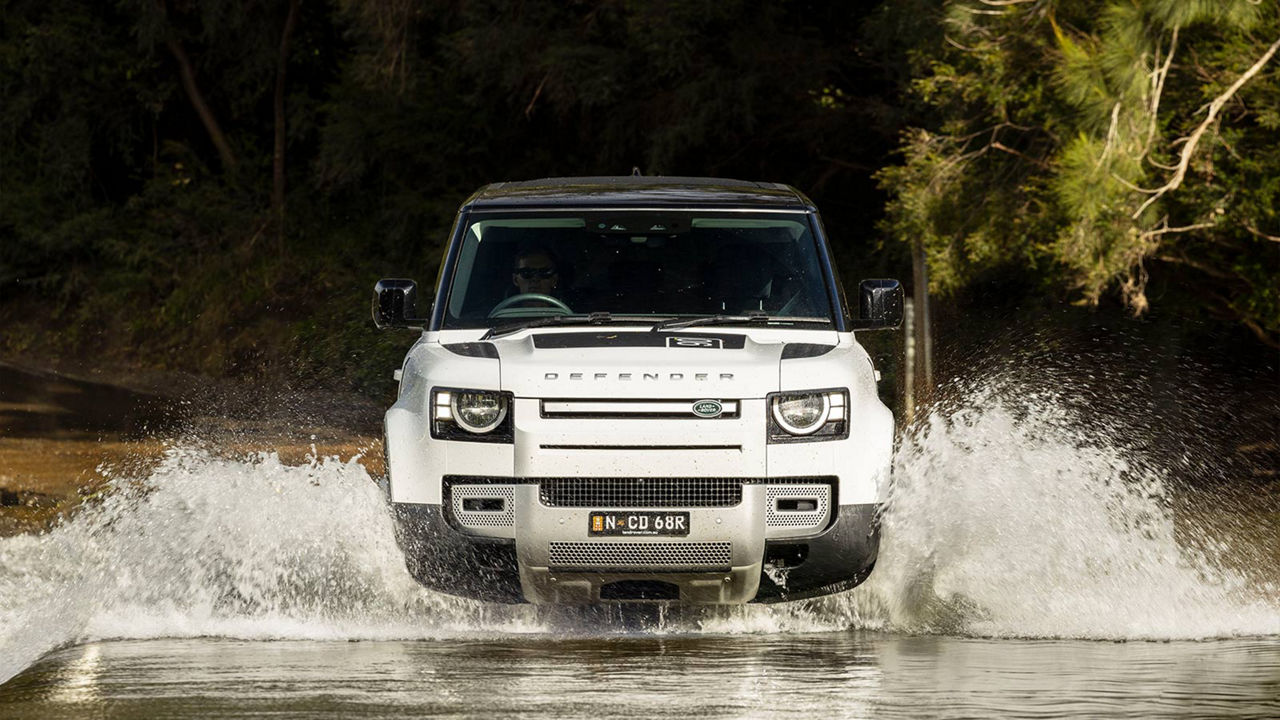 Defender driving through a river