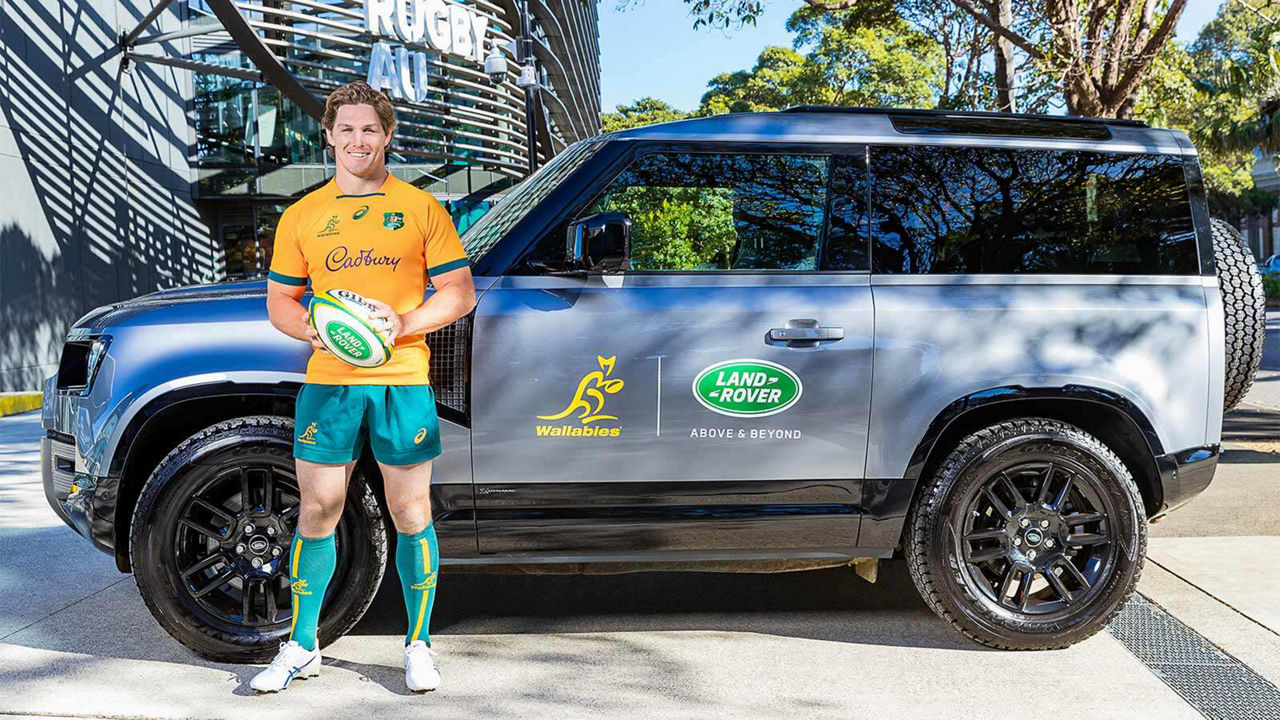 Rugby player standing infront of a Range Rover vehicle