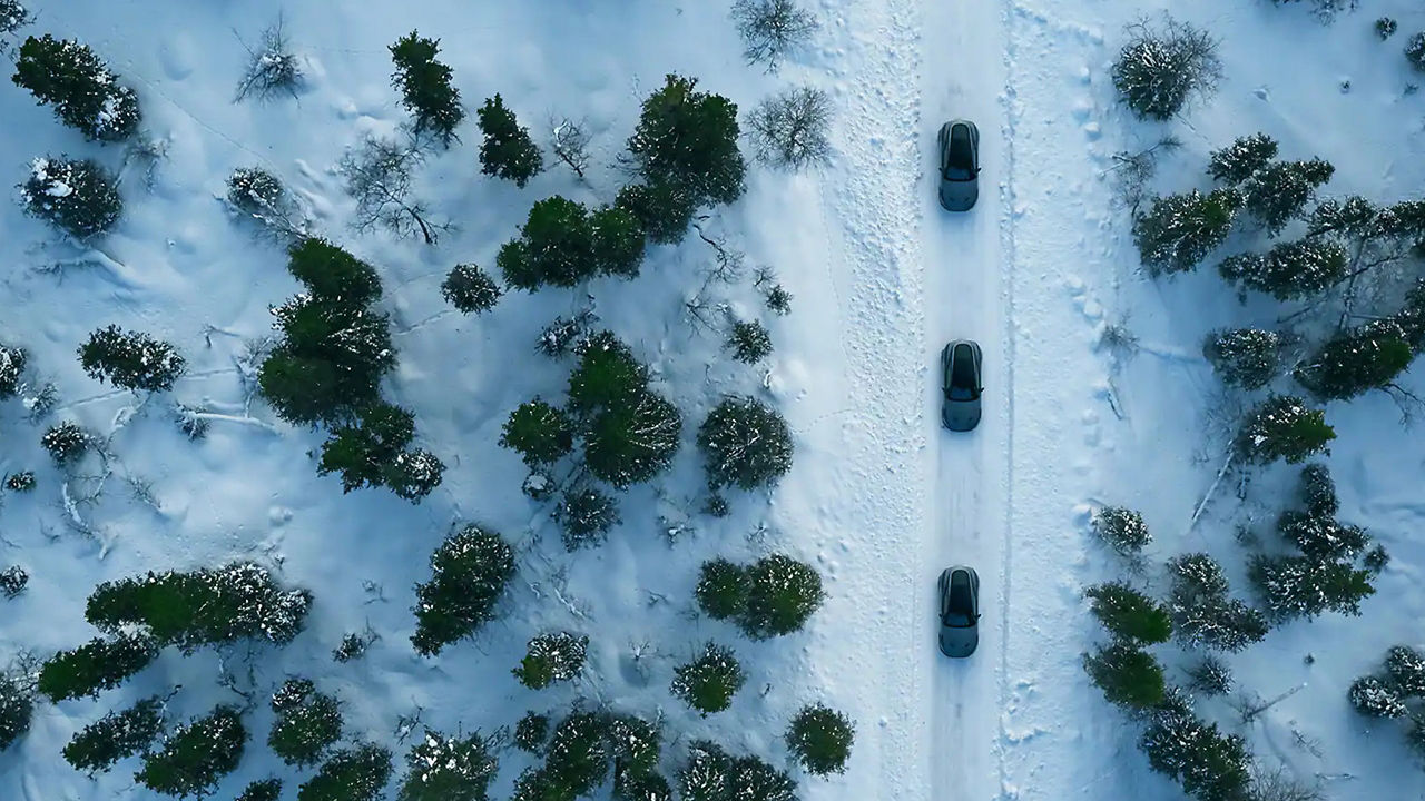Aerial view of snow-covered road tracks with car