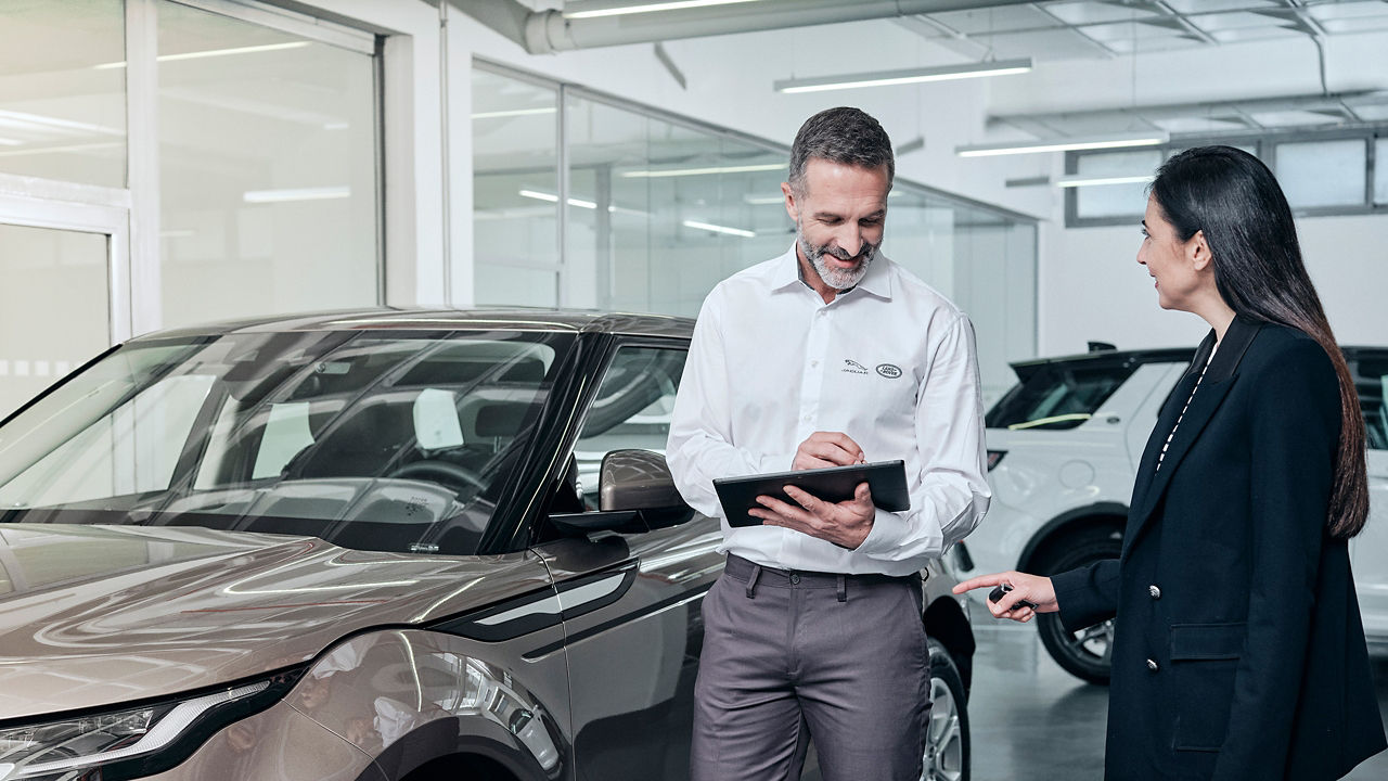 A sales person showing Land Rover Evoque in showroom