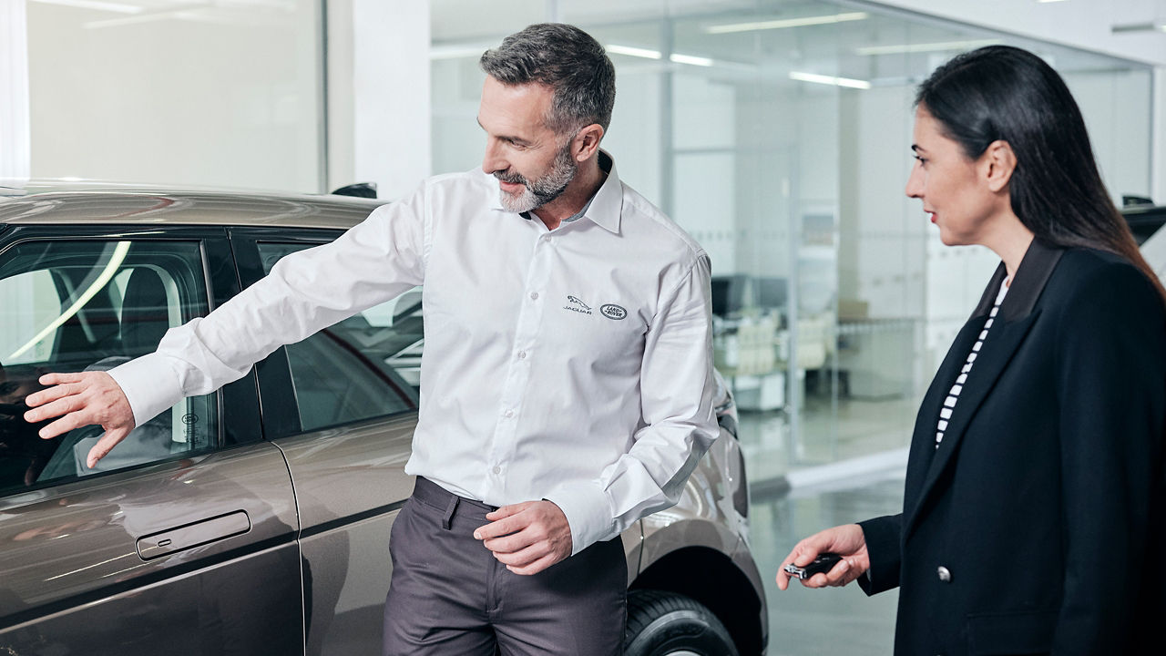 A sales person showing Land Rover Evoque in showroom