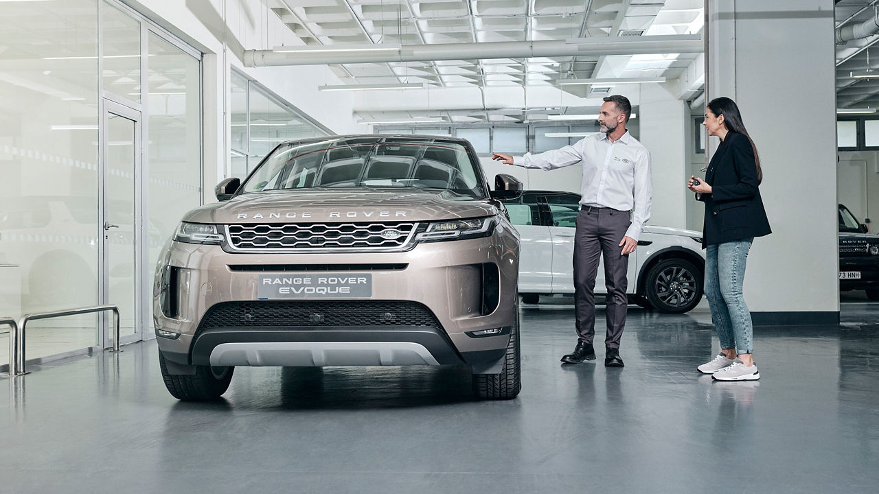 A sales person showing Land Rover Evoque in showroom