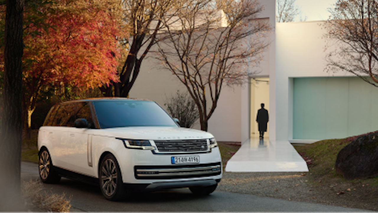 A Defender parked in the entry of a house and a person going inside the building