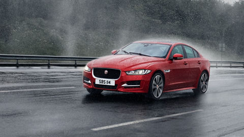 Jaguar XE running on road in rainy day