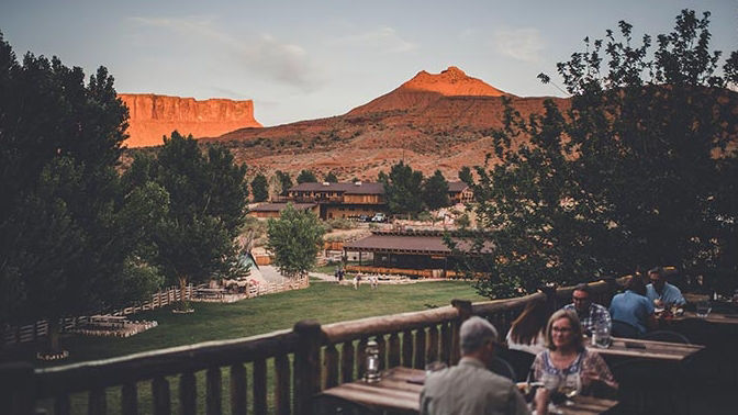 people sitting at a veranda in mountain background