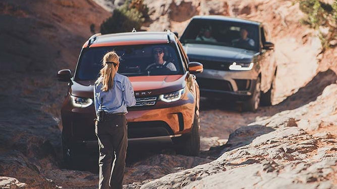 human giving instructions to land rover discovery drivers