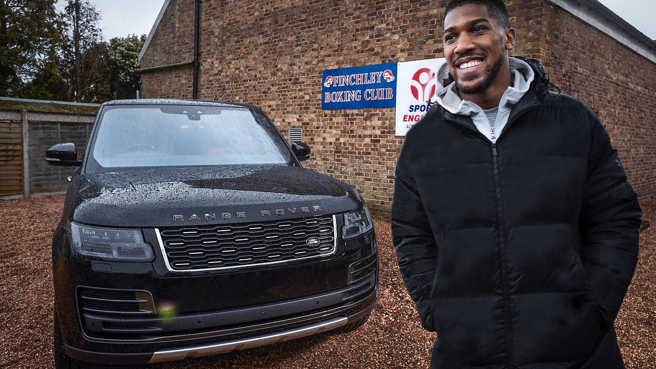 Anthony Joshua standing  near Range Rover 