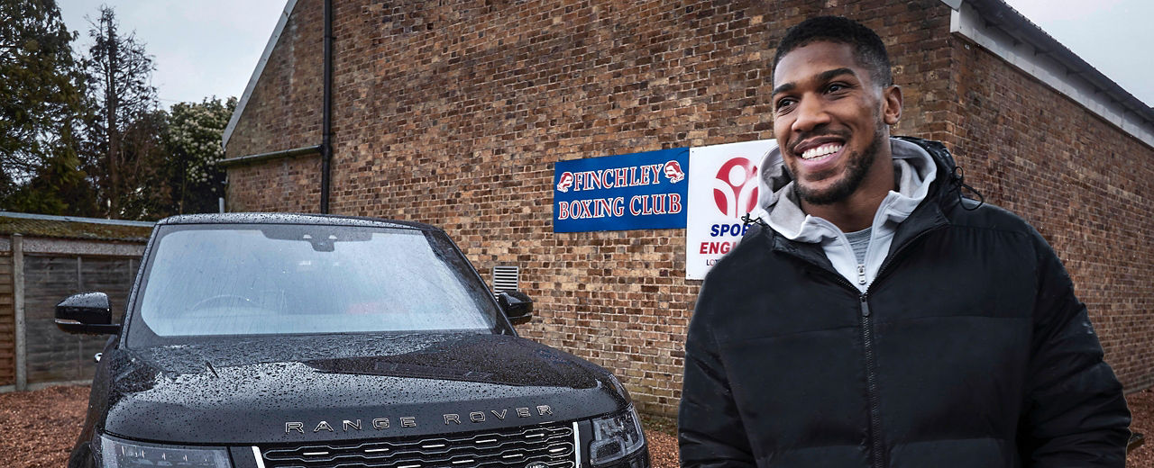 Anthony Joshua standing  near Range Rover 