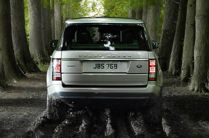 Range Rover driving with trees