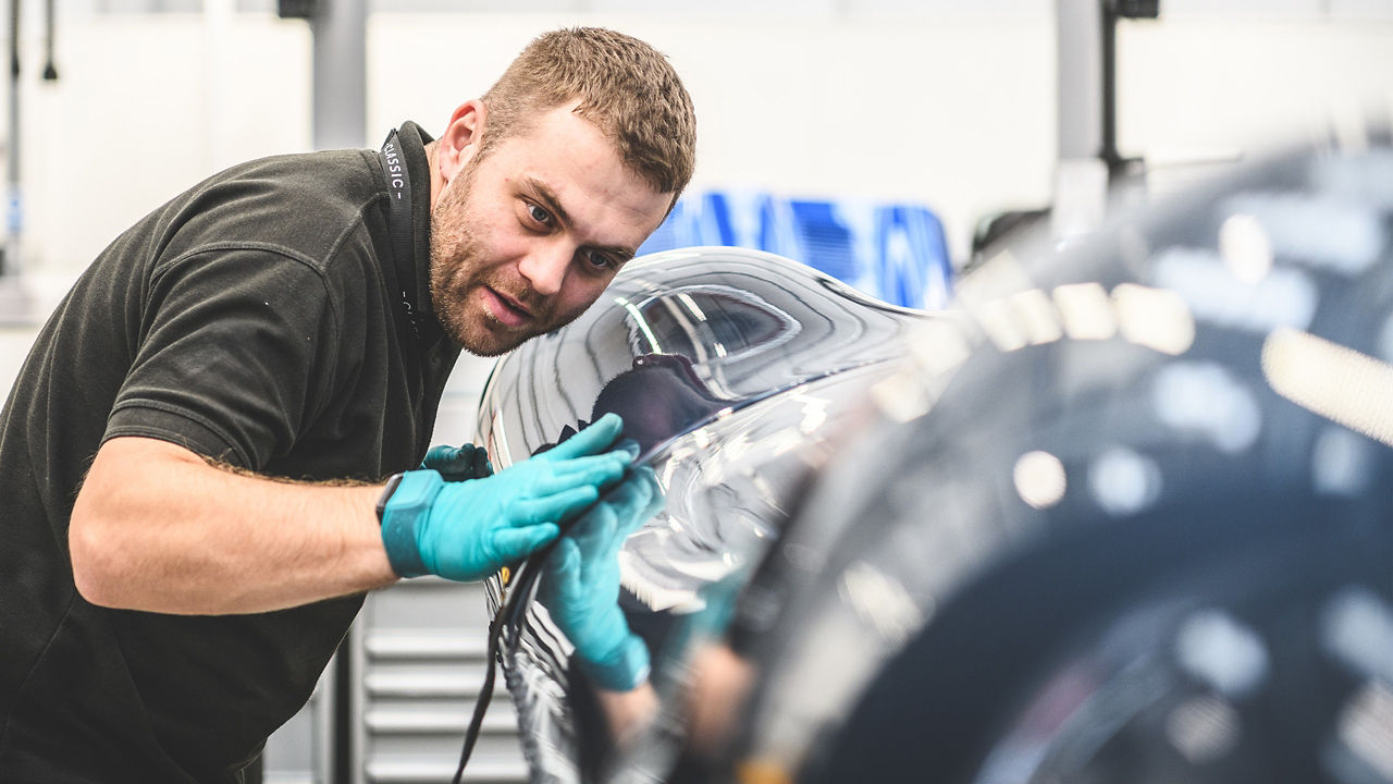 Man checking car body in workshop