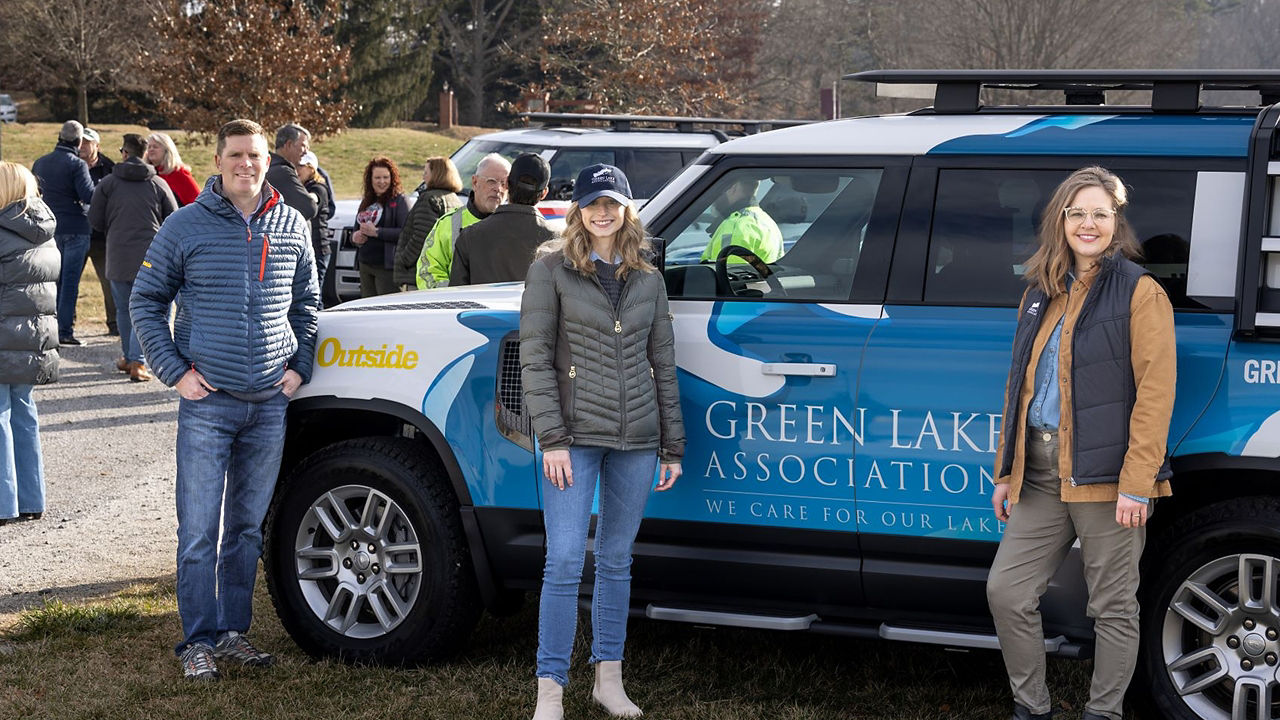 People posing in front of Defender Green Lake Association