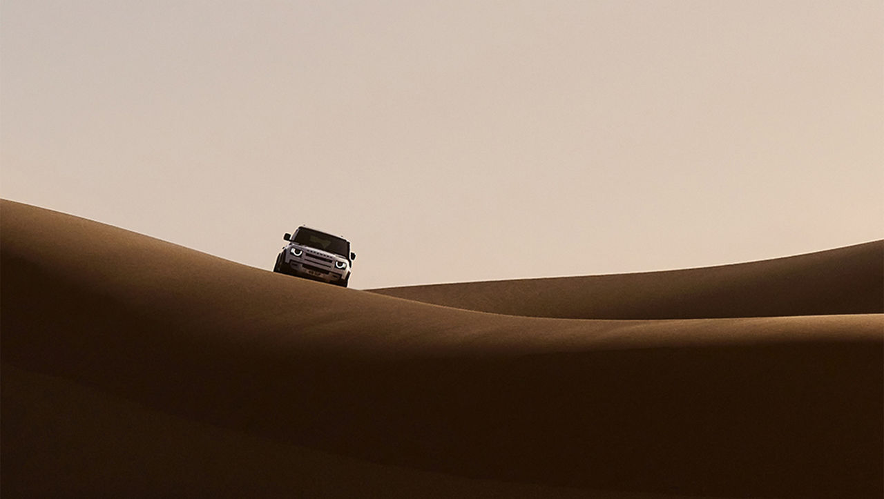 Defender Dakar in Desert hill road.