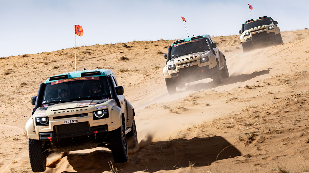Defender driving through the dessert at Dakar Rally.