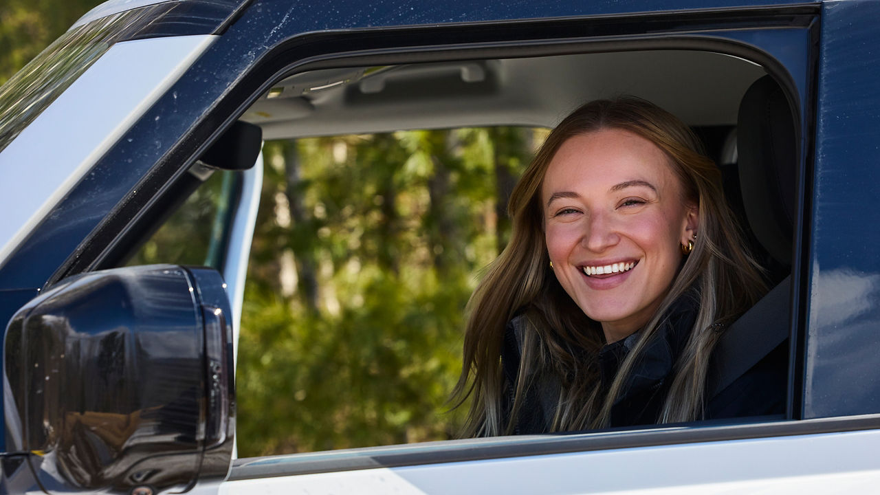 A girl is smiling sitting in the car