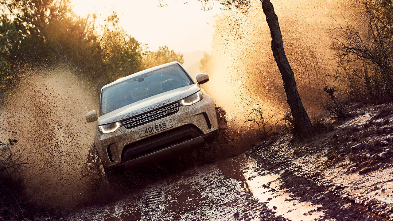 Discovery drive crosses the mud obstacle on the forest off-road