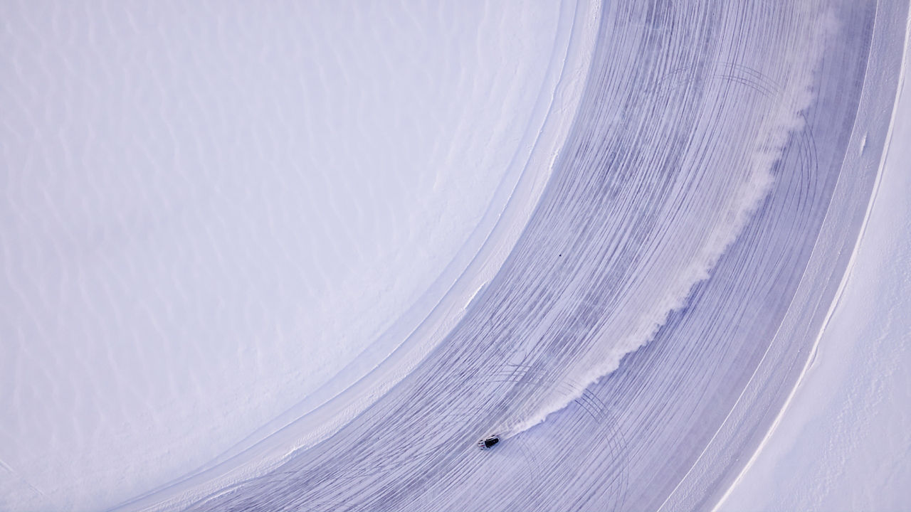 Aerial view, Sport car racing on snow race track in winter