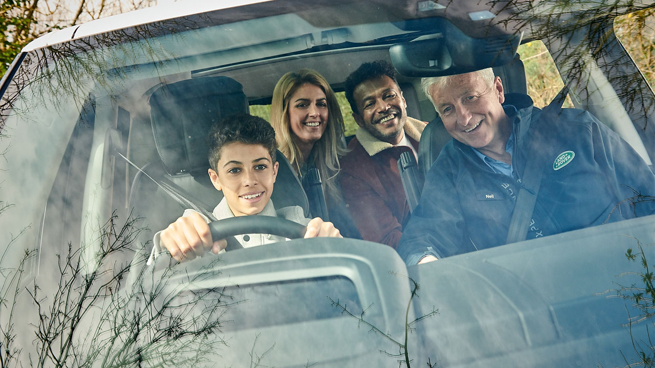 father pointing on something while teaching son driving car