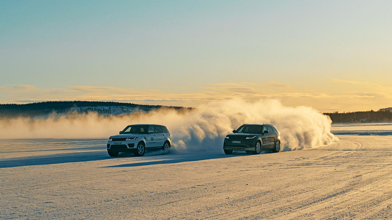 Two Velars driving in the snow next to each other