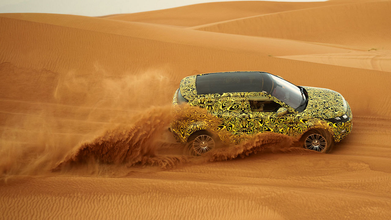 Land Rover vehicle driving through sand, testing hot weather