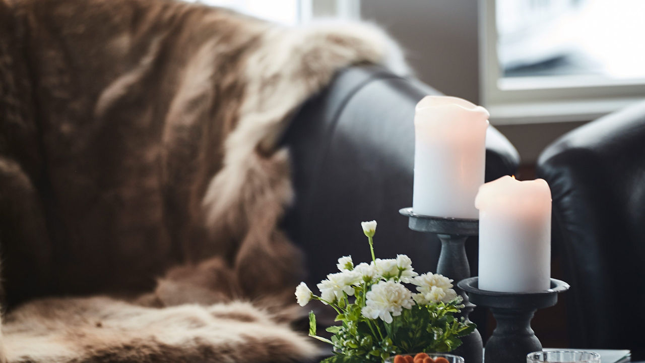 Flower vase and candle on the coffee table over sofa