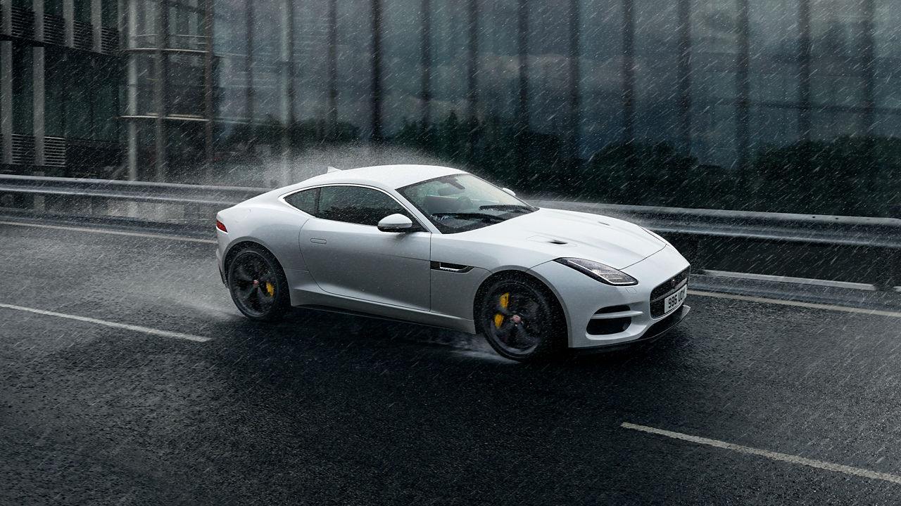 Jaguar F-Type running in heavy rain on city bridge