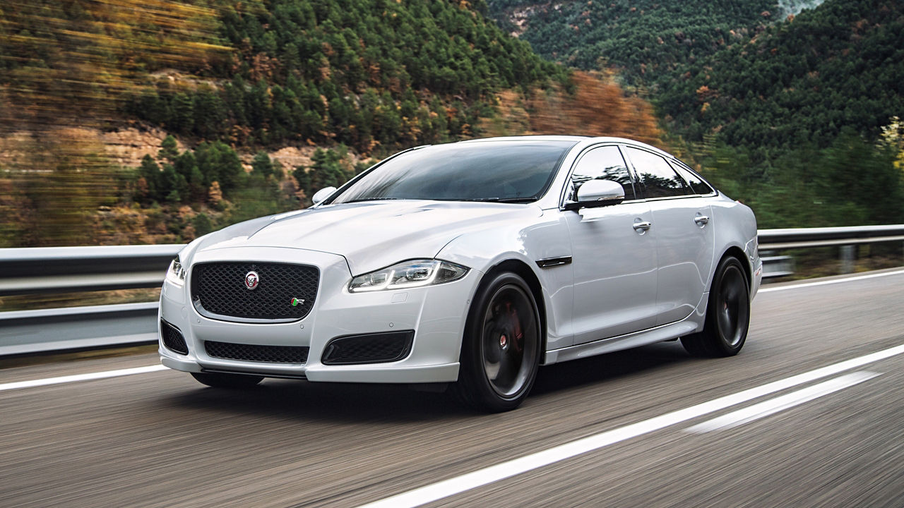 Jaguar XJ running on hill road