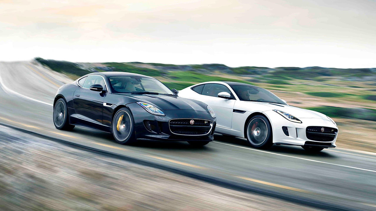Two Jaguar F-Type coupe racing on road