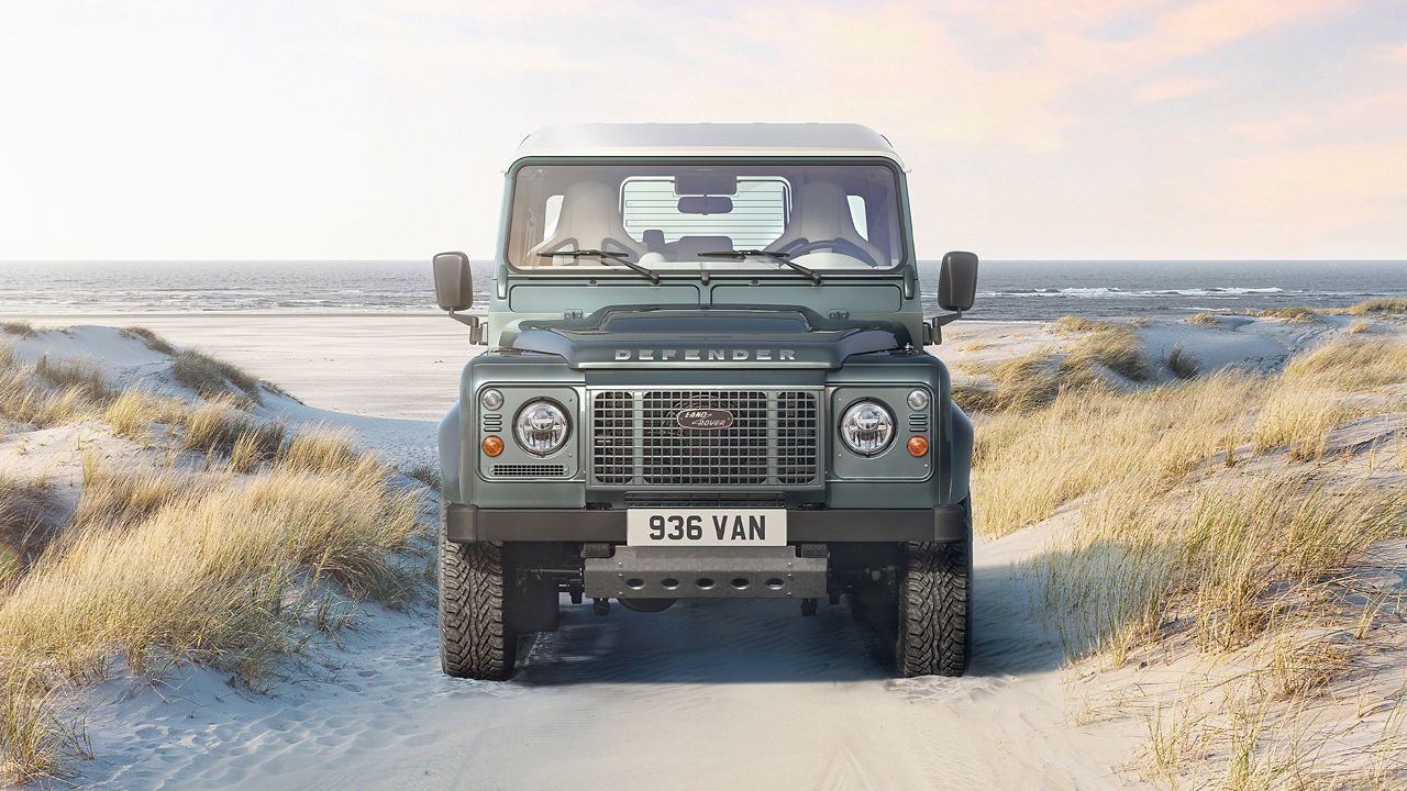 Classic Defender parked at outside of beach area