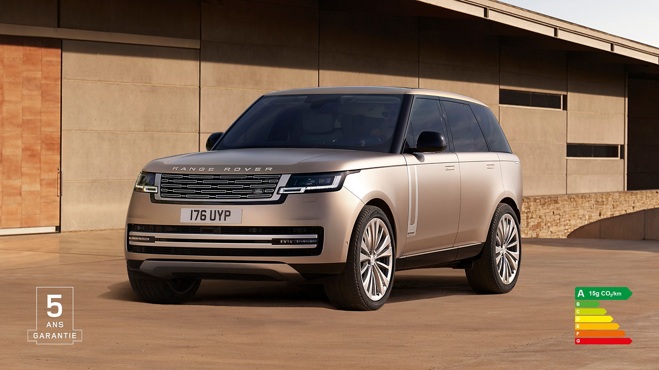 Range Rover in Sunset Gold parked outside of contemporary building with energy efficiency label A (15g CO2/km) and 5 years warranty watermark.
