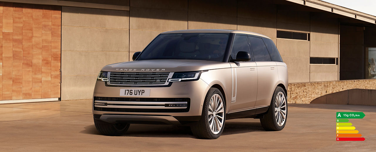 Range Rover in Sunset Gold parked outside of contemporary building with energy efficiency label A (15g CO2/km).