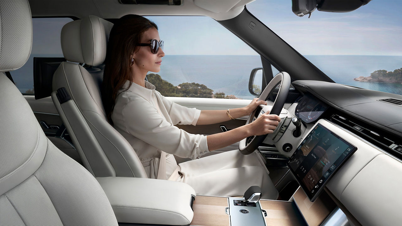 woman driving Range Rover by the sea