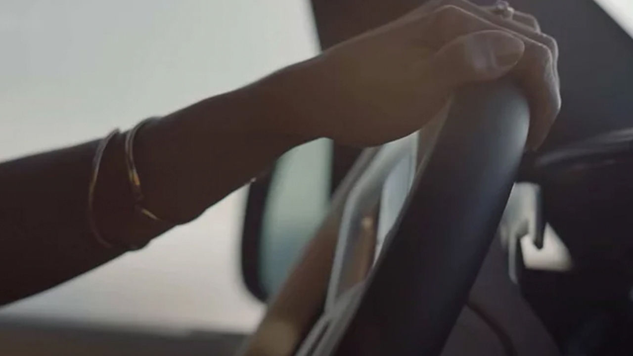 Woman's hands holding Range Rover steering wheel