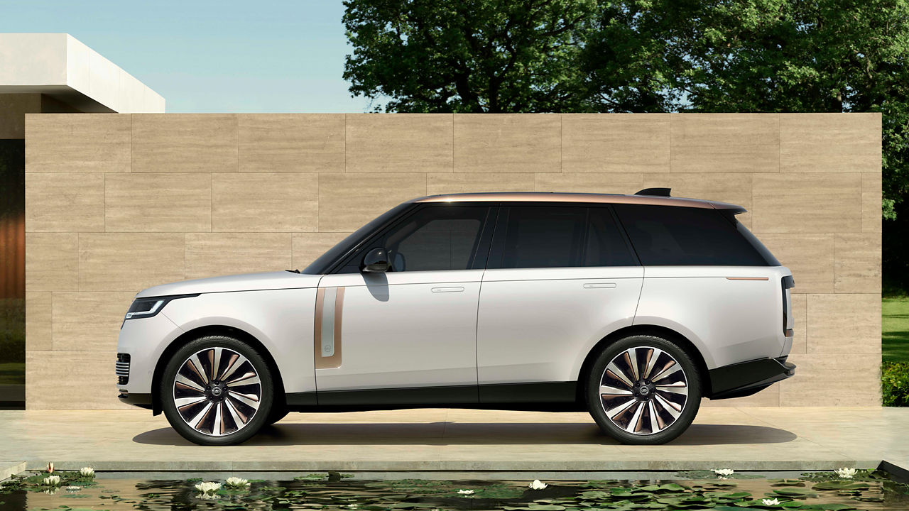 Range Rover in Oustuni Pearl White parked behind the pond in a contemporary garden.