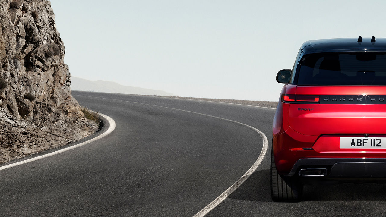 rear view of Range Rover Sport driving through mountain road