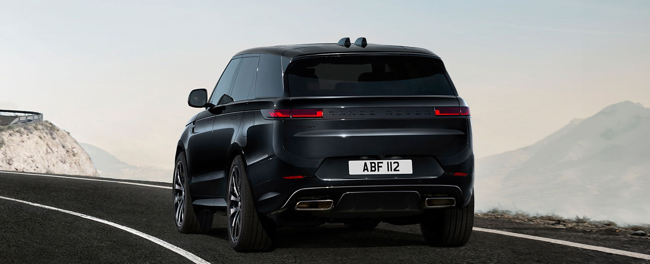 Rear view of Range Rover Sport in Santorini Black driving on road.